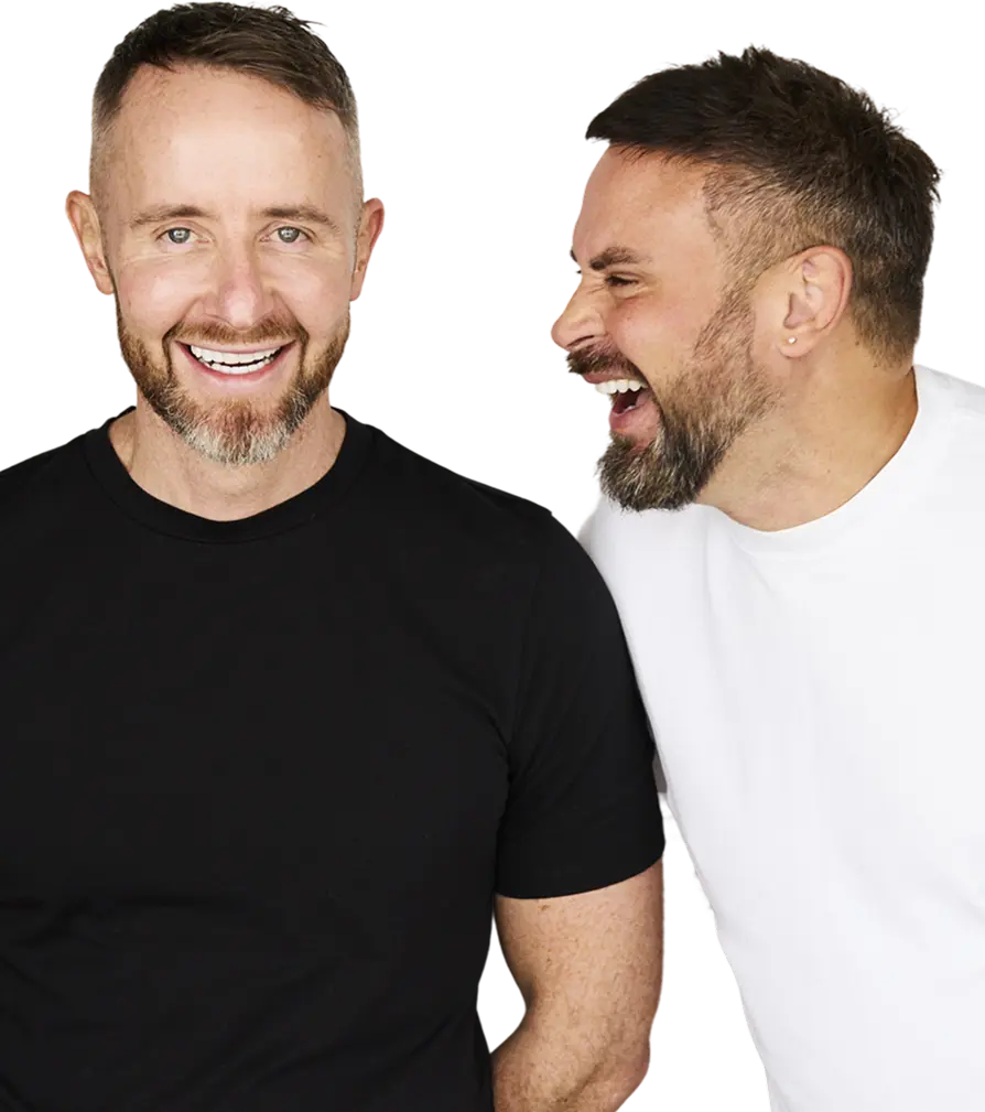 Two men laughing and standing next to each other.
