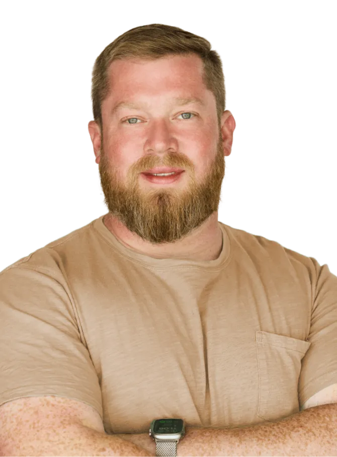 A man with a beard wearing a tan shirt.