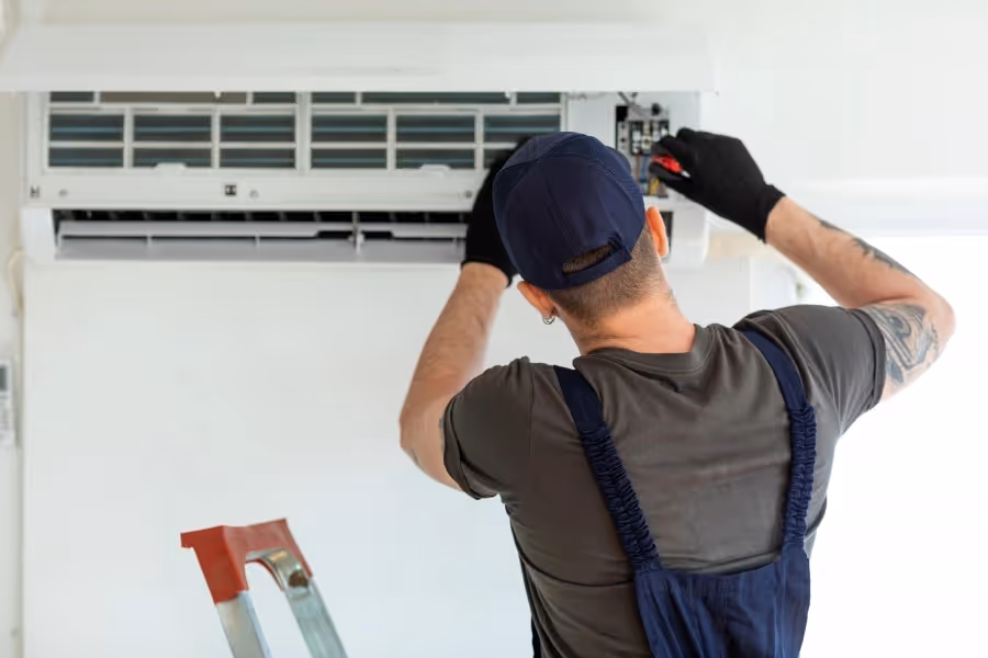 Air conditioner repair technician working indoors.