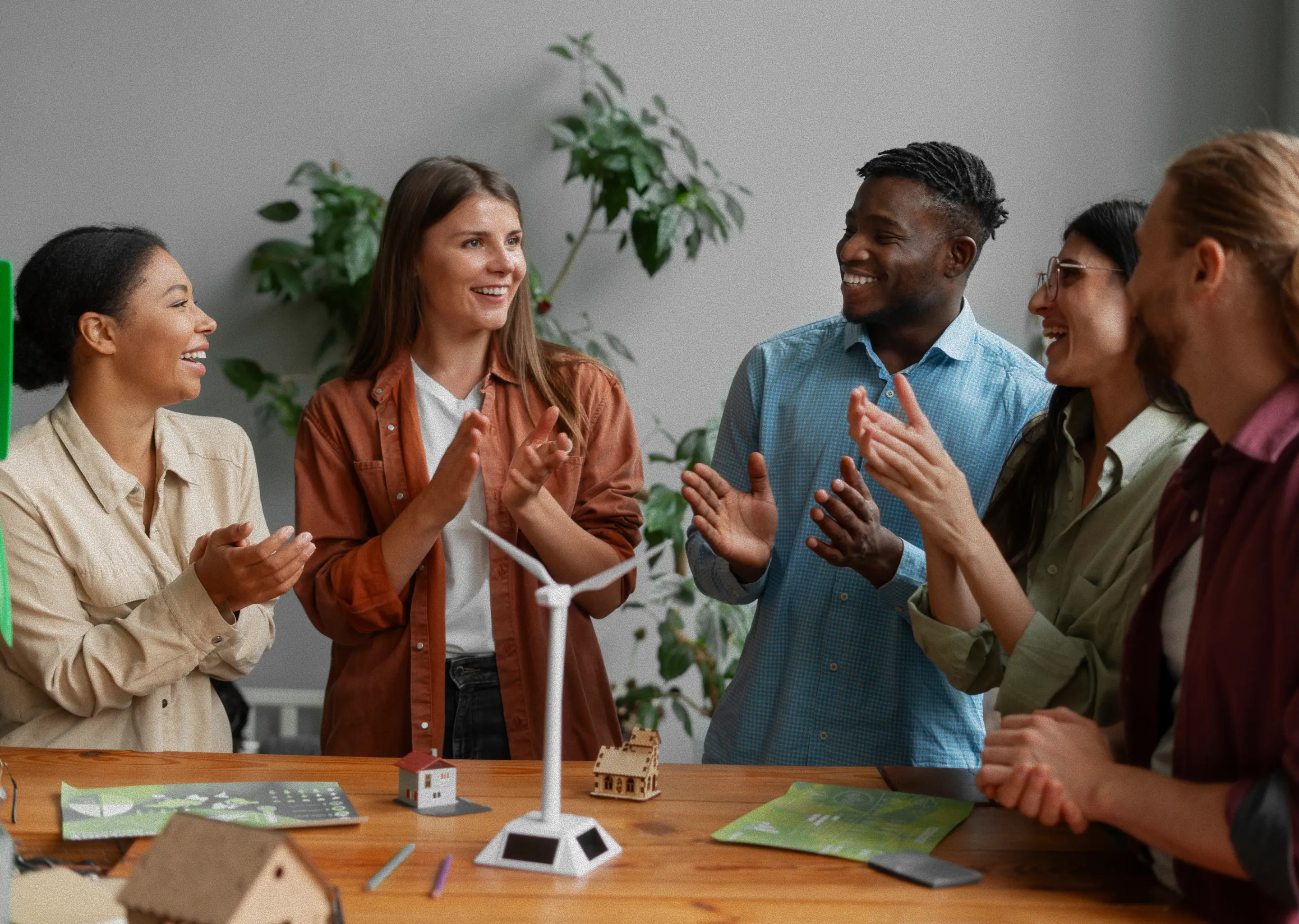 Group of students clapping together at the end of a classroom presentation.