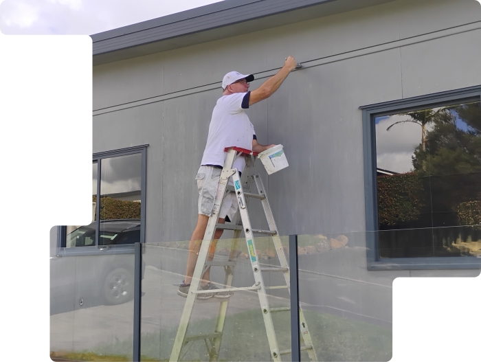 Glenn painting a house in Paihia, Northland