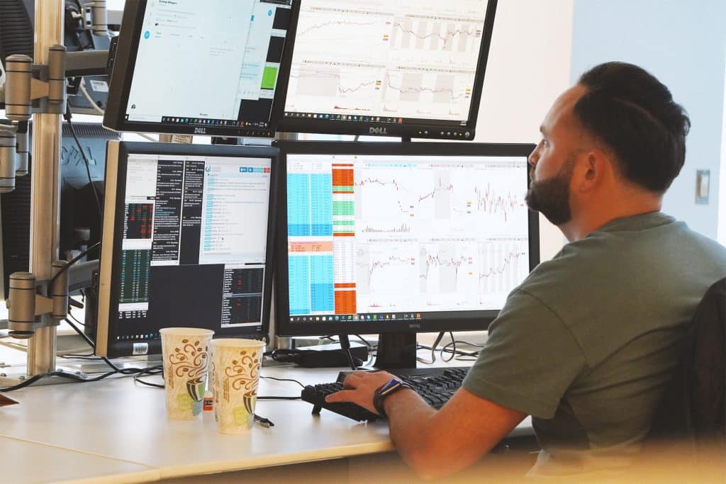 man trading on mulitple screens - Profitable Gold Trading Strategy