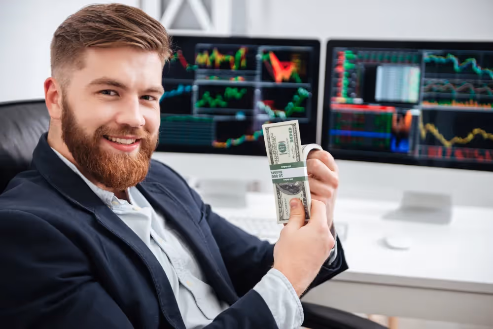 man smiling and holding dollar bills - Why Do Most Day Traders Fail