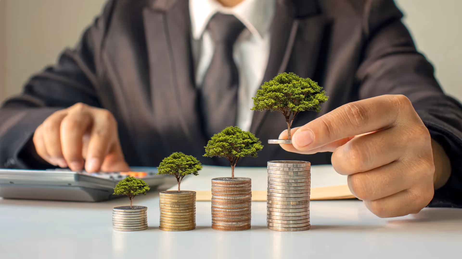 man piling stack of coins - Day Trading vs Long Term Investing