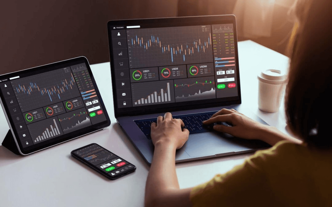 Person trading stocks on multiple devices - Best Currency Pairs to Trade for Beginners 
