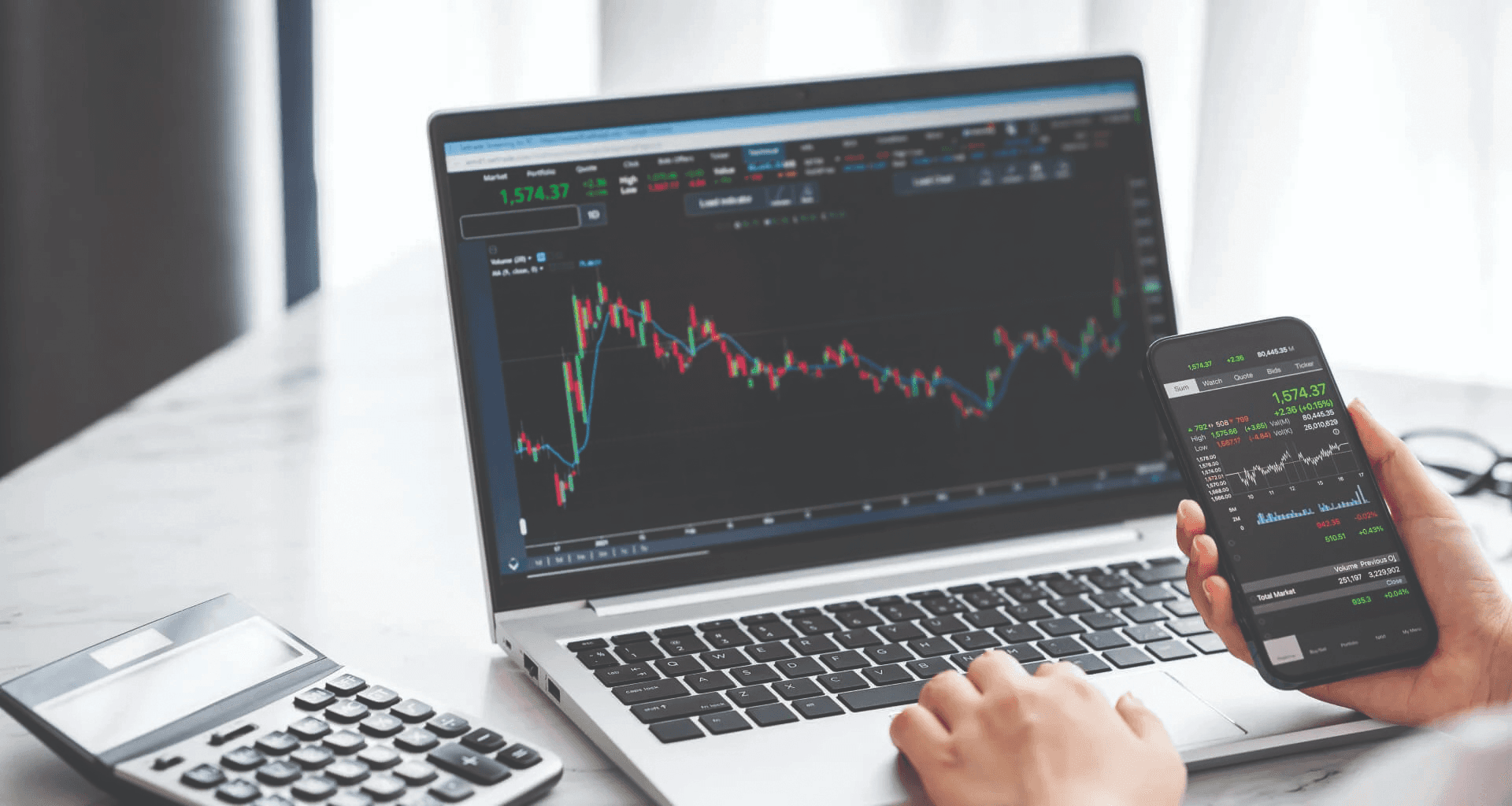 Laptop and smartphone showing financial charts - Online Forex Trading