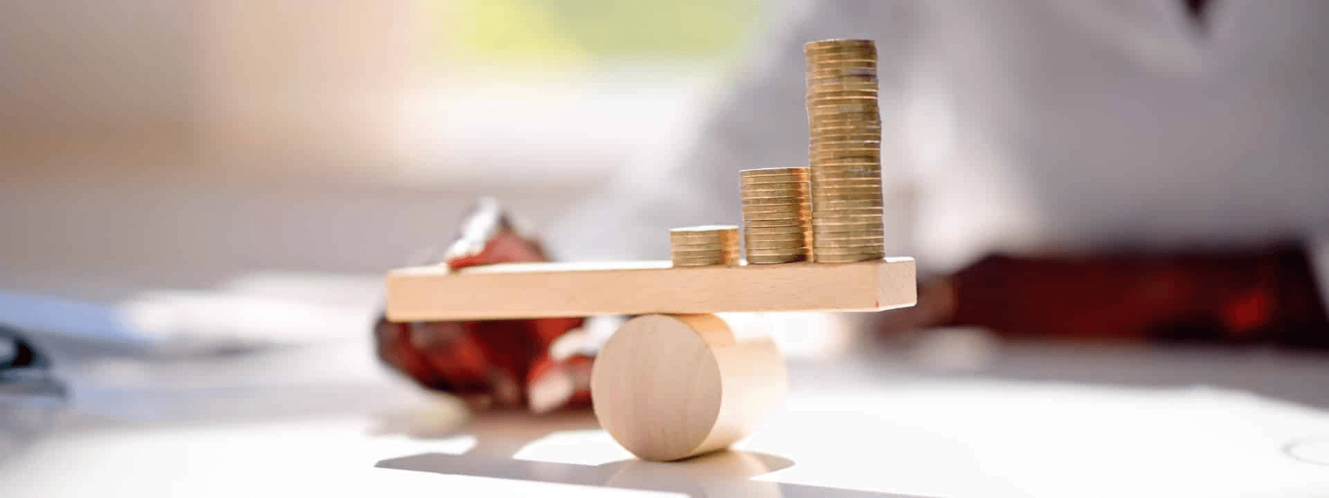 Stacked coins balanced on wooden lever - Trading Leverage