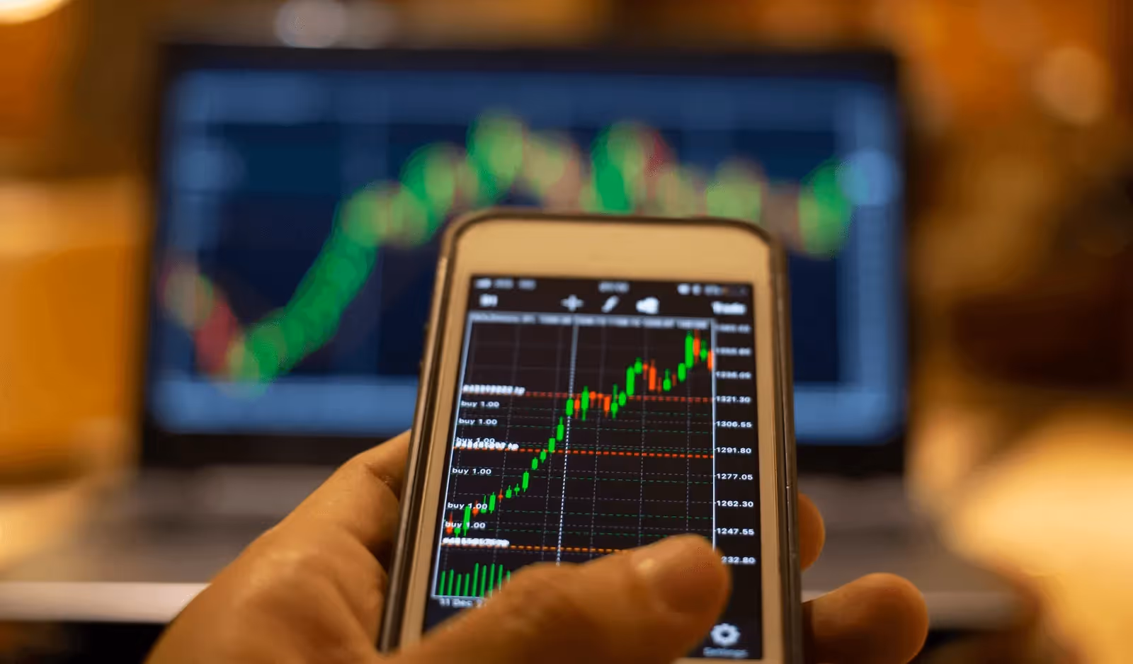  Hand holding phone tracking stock market - Sources of Capital
