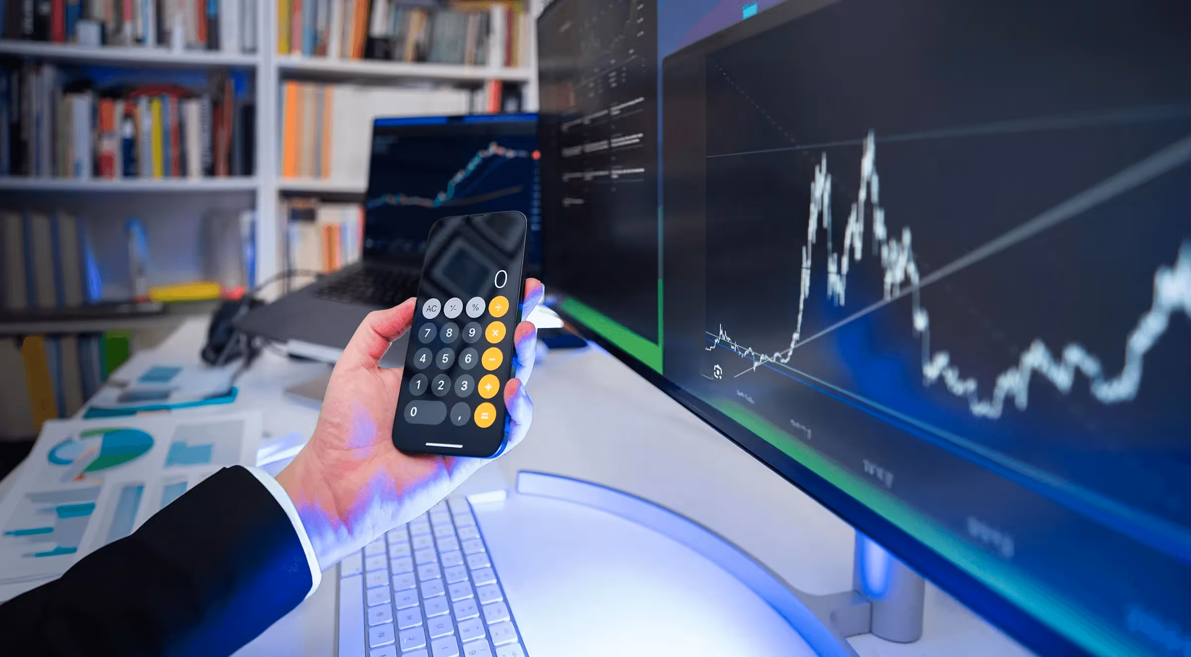  Trader using calculator with market chart - Forex Capital Trading