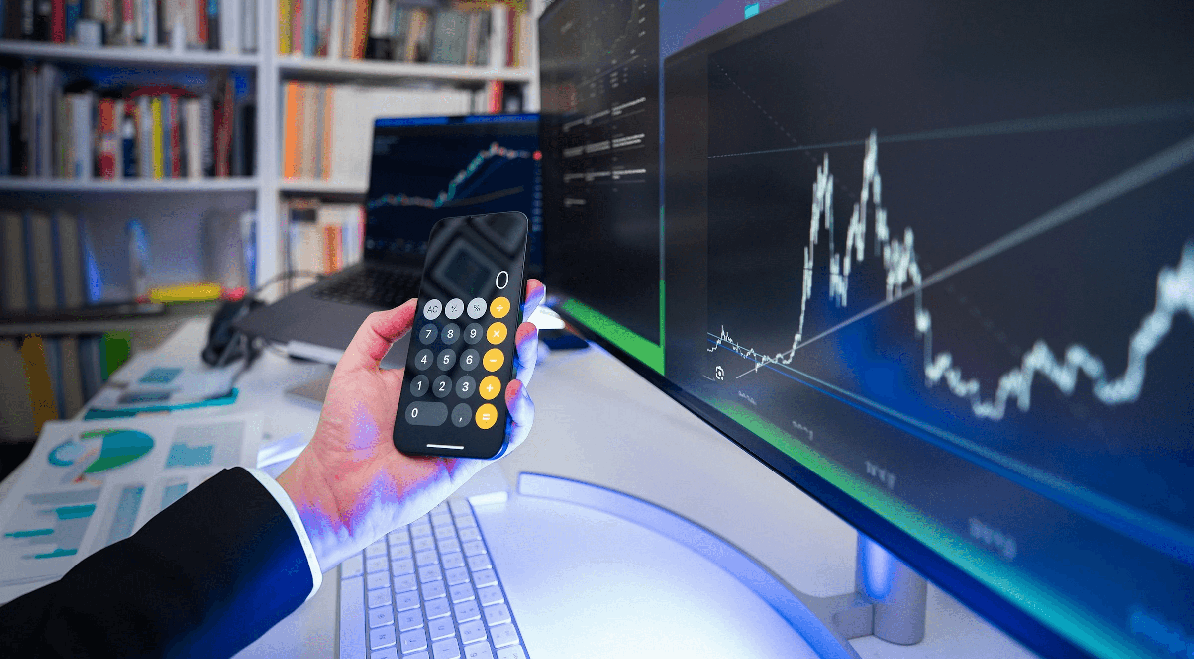 Trader using calculator with market chart - Forex Capital Trading