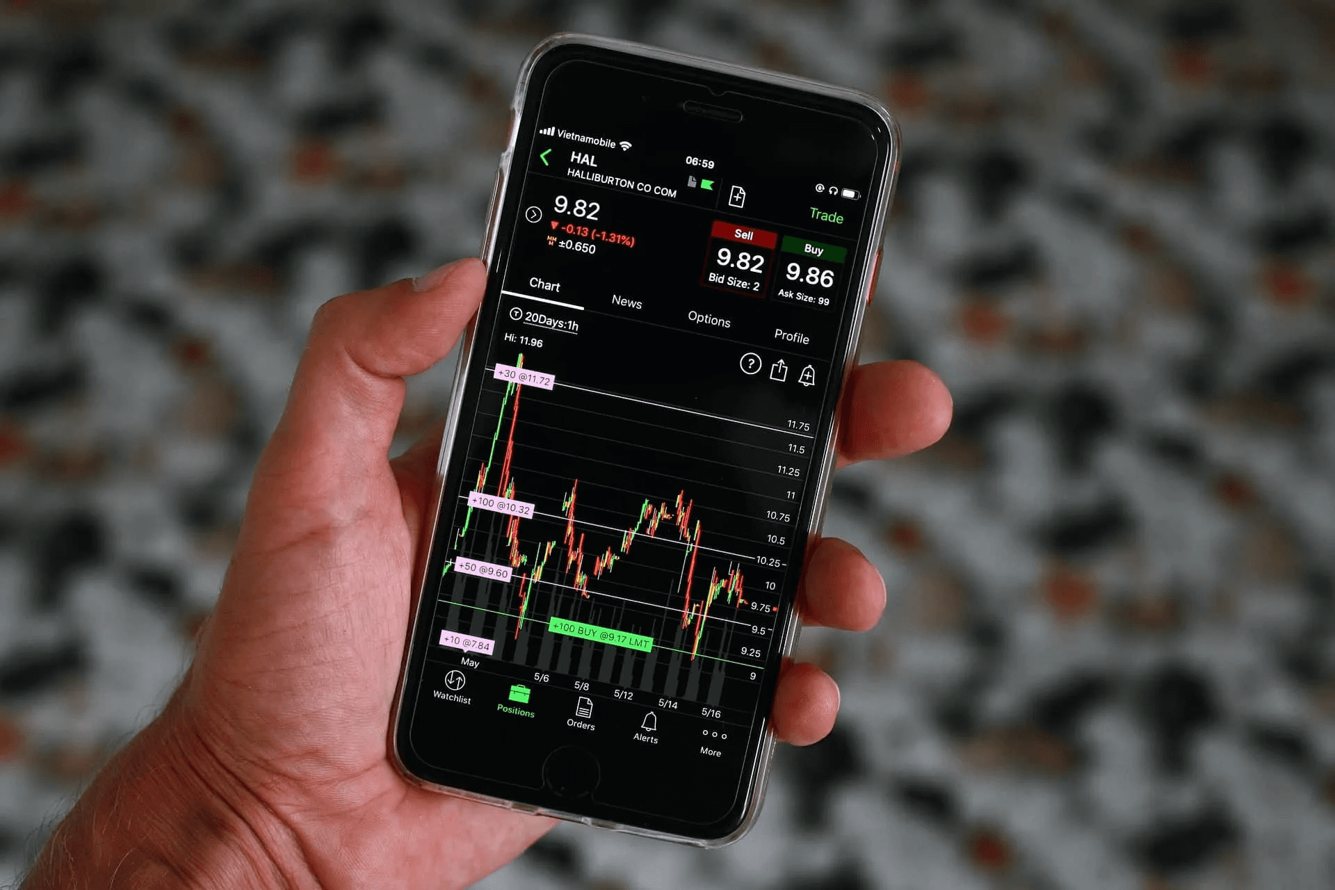 Person holding phone displaying stock app -  Stop Loss vs Stop Limit