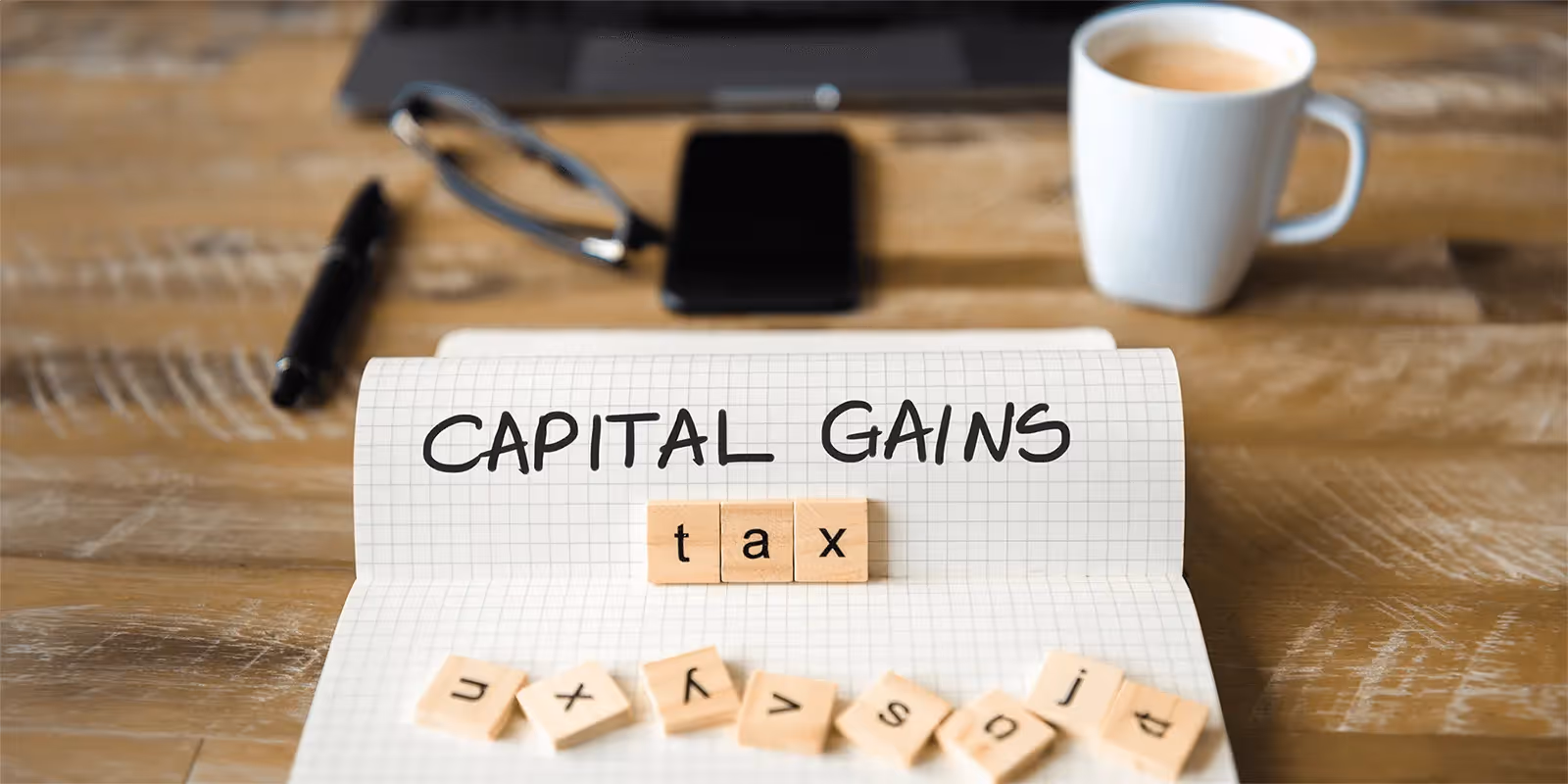 Notebook with capital gains tax text - Short Term Capital Gain Tax on Shares