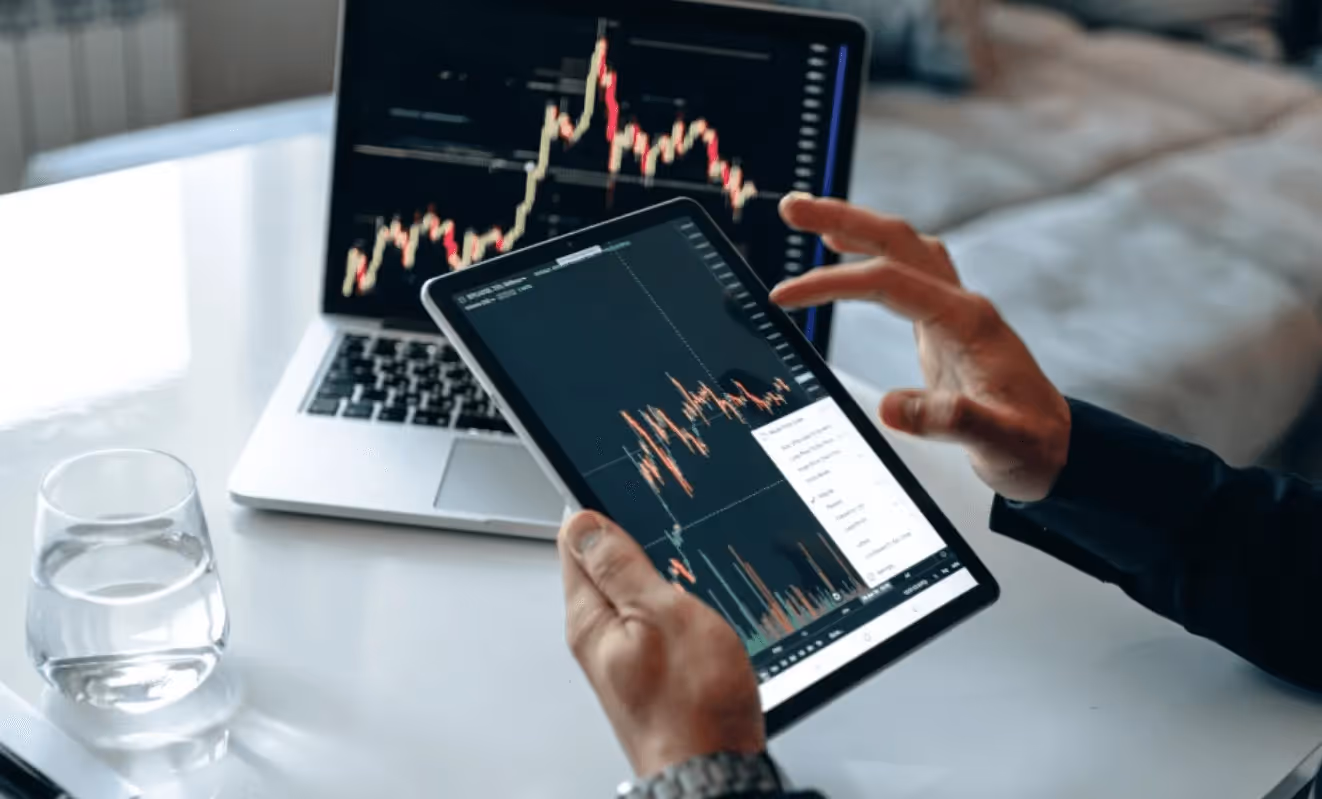 Person monitoring stock market on devices - FTMO vs Topstep