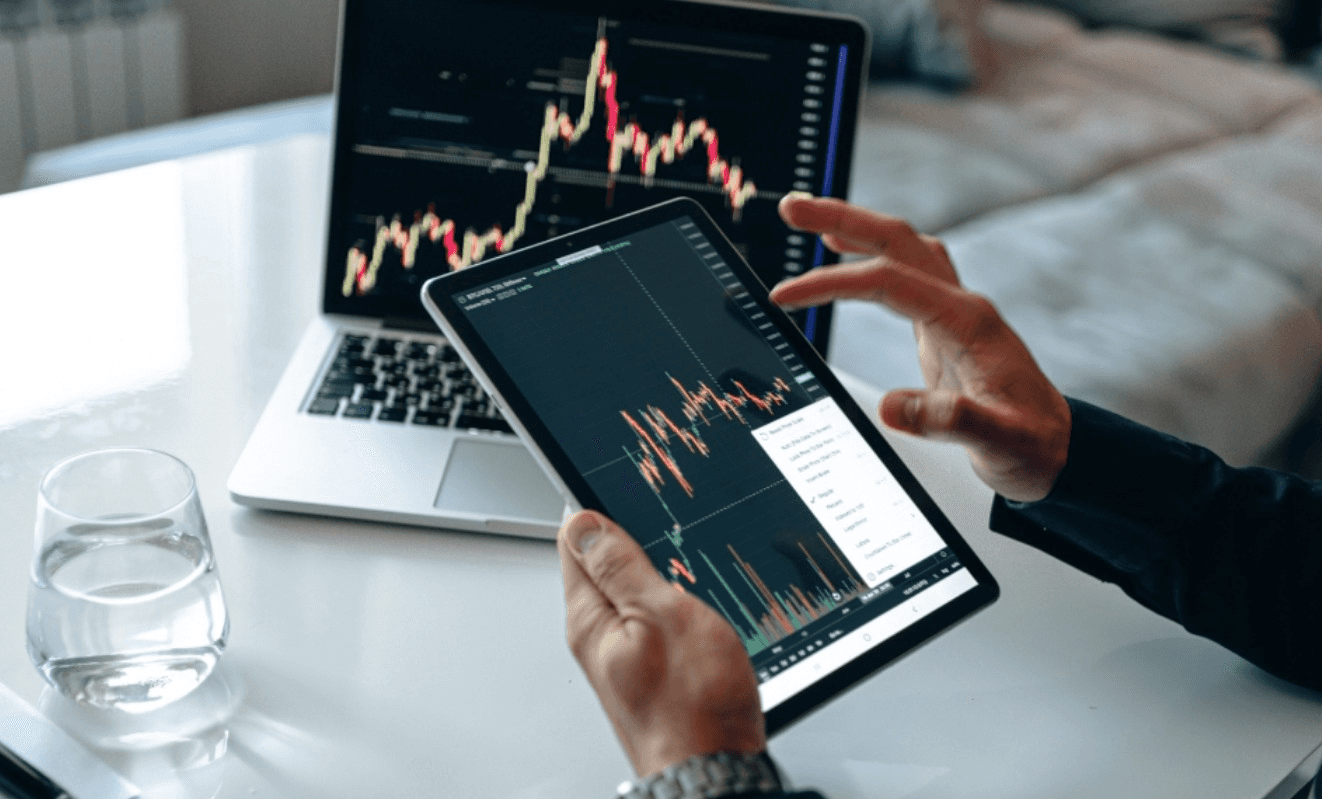 Person monitoring stock market on devices - FTMO vs Topstep