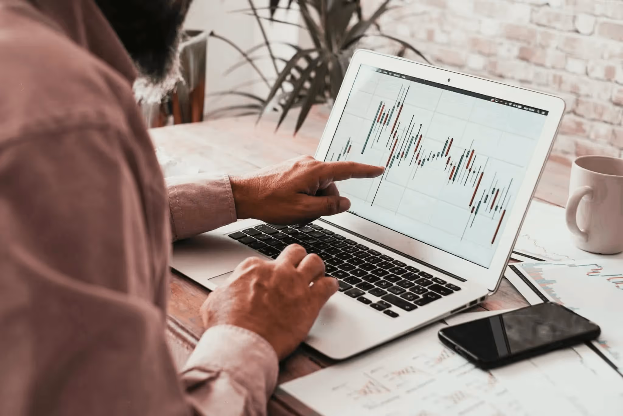 Man pointing towards laptop screen - Proprietary Trading Firms
