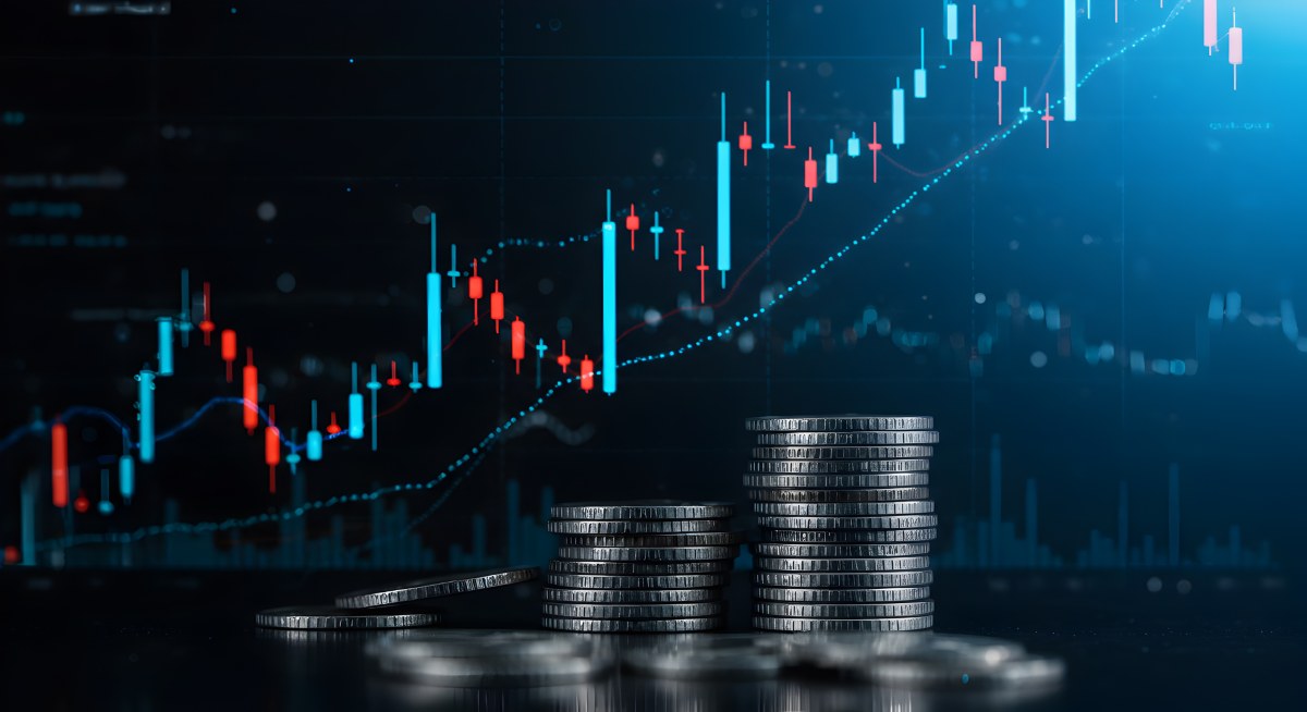 Stacks of coins growing in value against a dynamic background of a financial chart