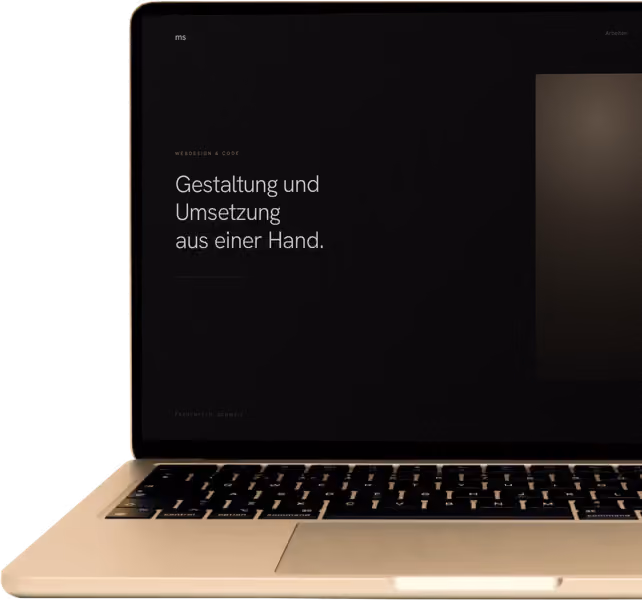 A golden MacBook showing a website designed by Marcel Schreiner