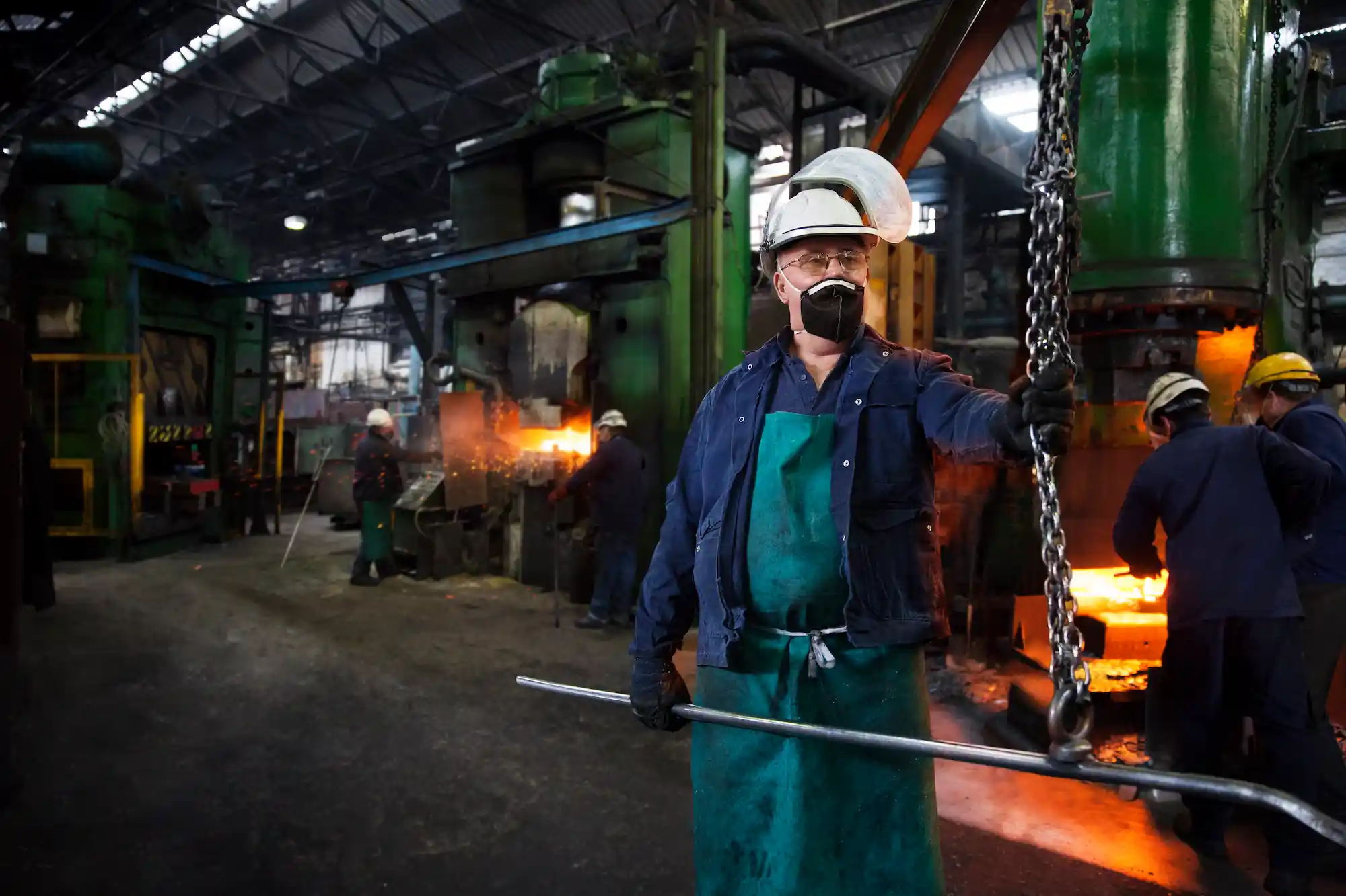 Operative prepares to hook steel billet out of fur