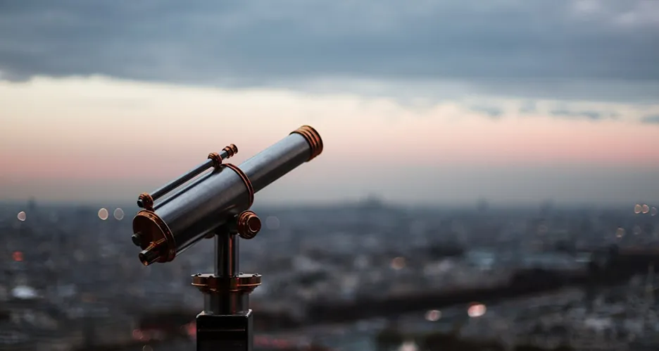 A telescope with a city in the background