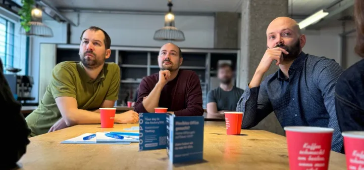 4 people sitting around a table looking concentrated