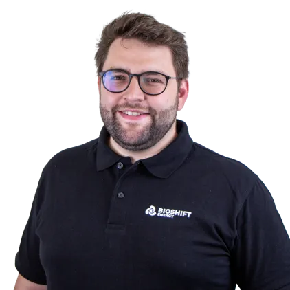 Portrait of a team member of BIOSHIFT in a black polo shirt with their company logo