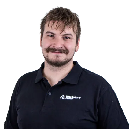Portrait of a team member of BIOSHIFT in a black polo shirt with their company logo