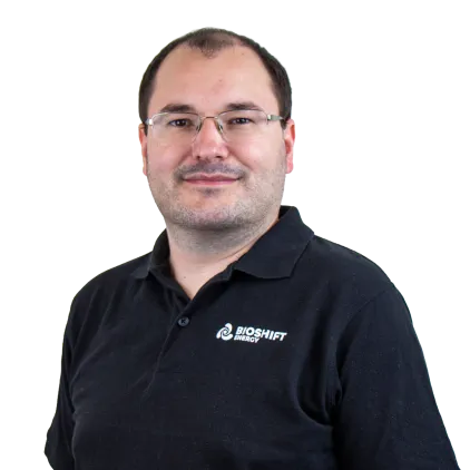 Portrait of a team member of BIOSHIFT in a black polo shirt with their company logo