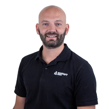 Portrait of a team member of BIOSHIFT in a black polo shirt with their company logo