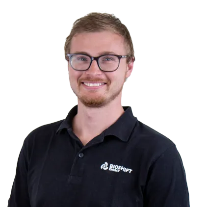 Portrait of a team member of BIOSHIFT in a black polo shirt with their company logo