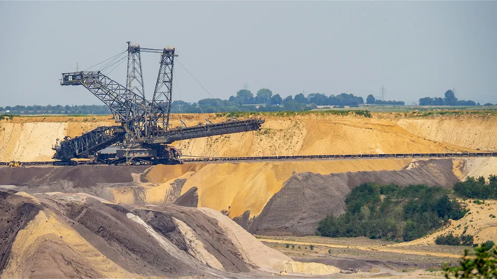 A vast open-cast mining scene with a big mining machine mining the ground