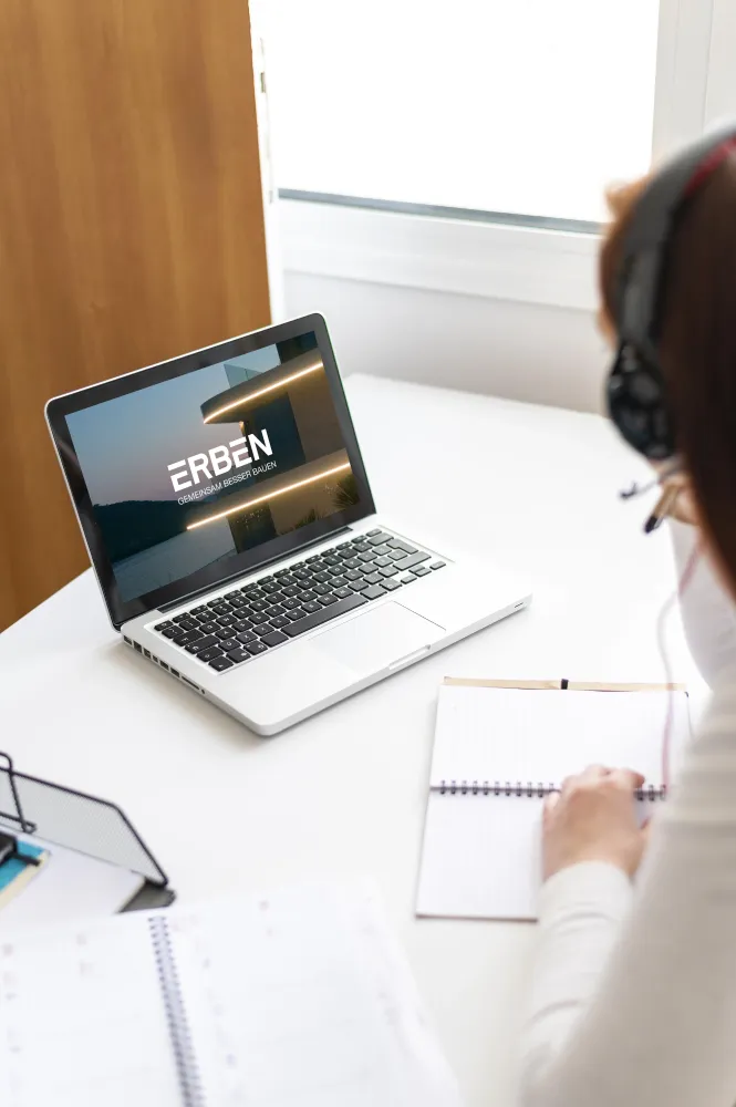 Erben Bau Close up worker at desk in front of laptop