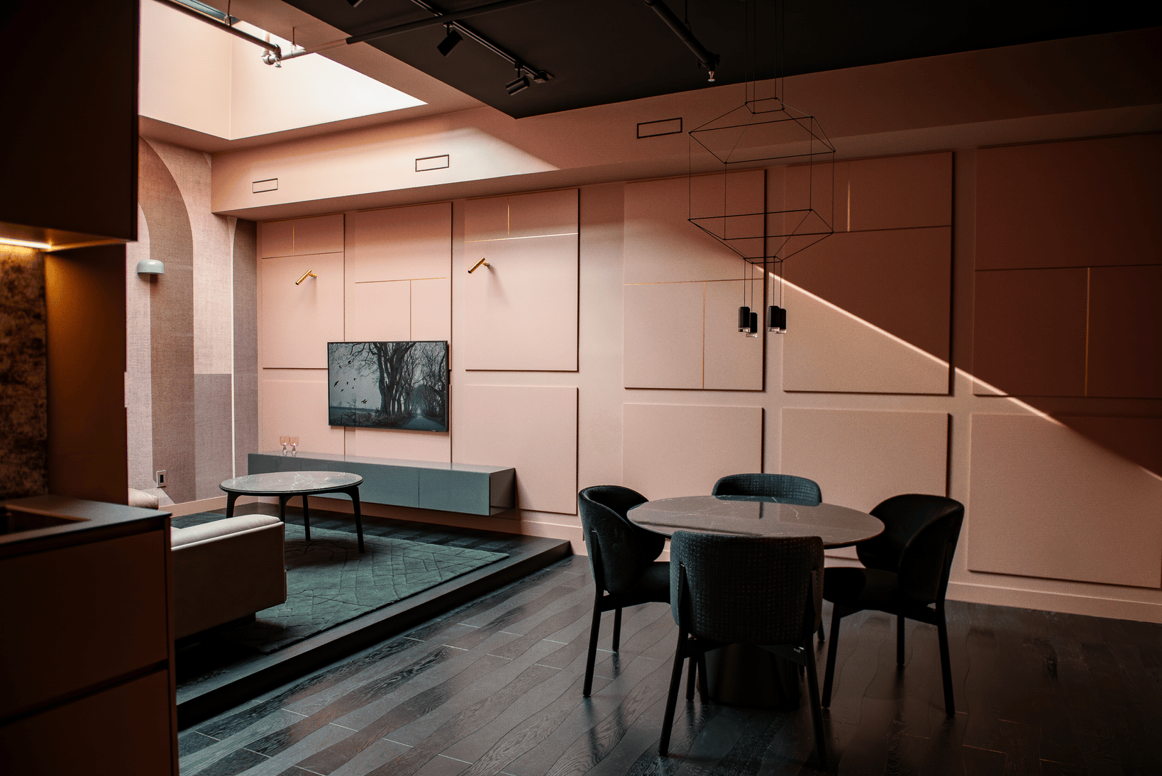 Modern living and dining area with dark wood floor, round dining table with four chairs, wall-mounted TV, and large windows letting in natural light.