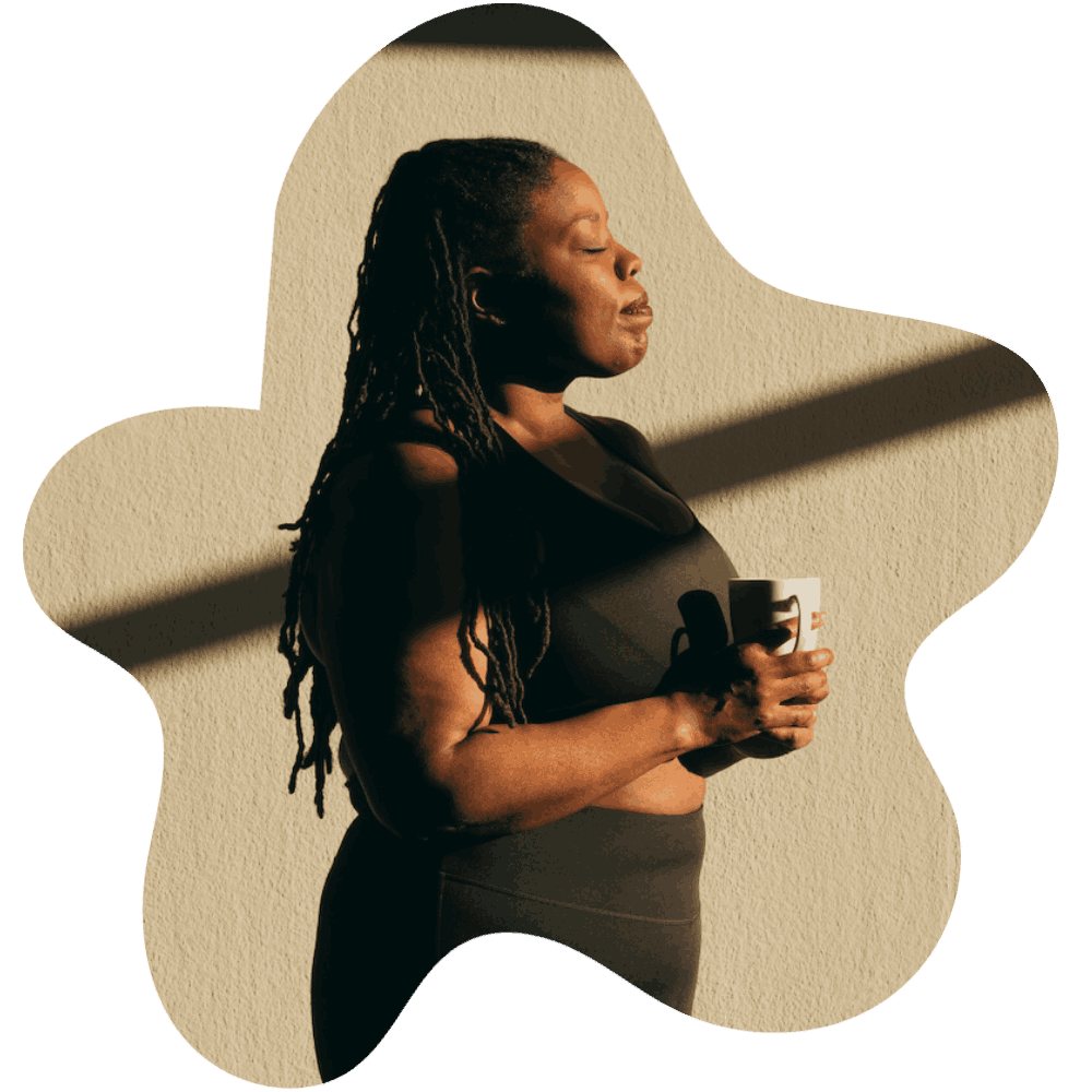 A cutout shape with the image of a woman holding a cup of coffee standing within the shape. 