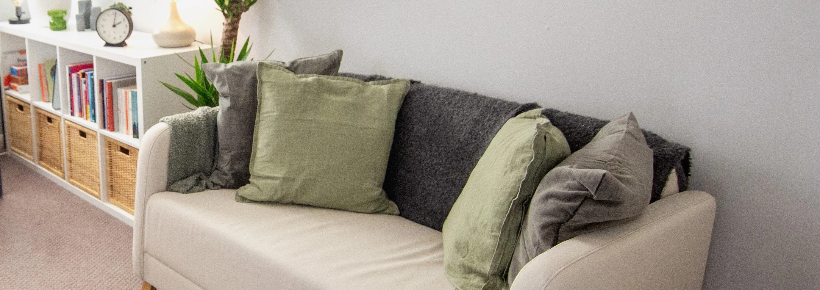Inside the Anchor Counselling office space, showing a white sofa with green cushions 