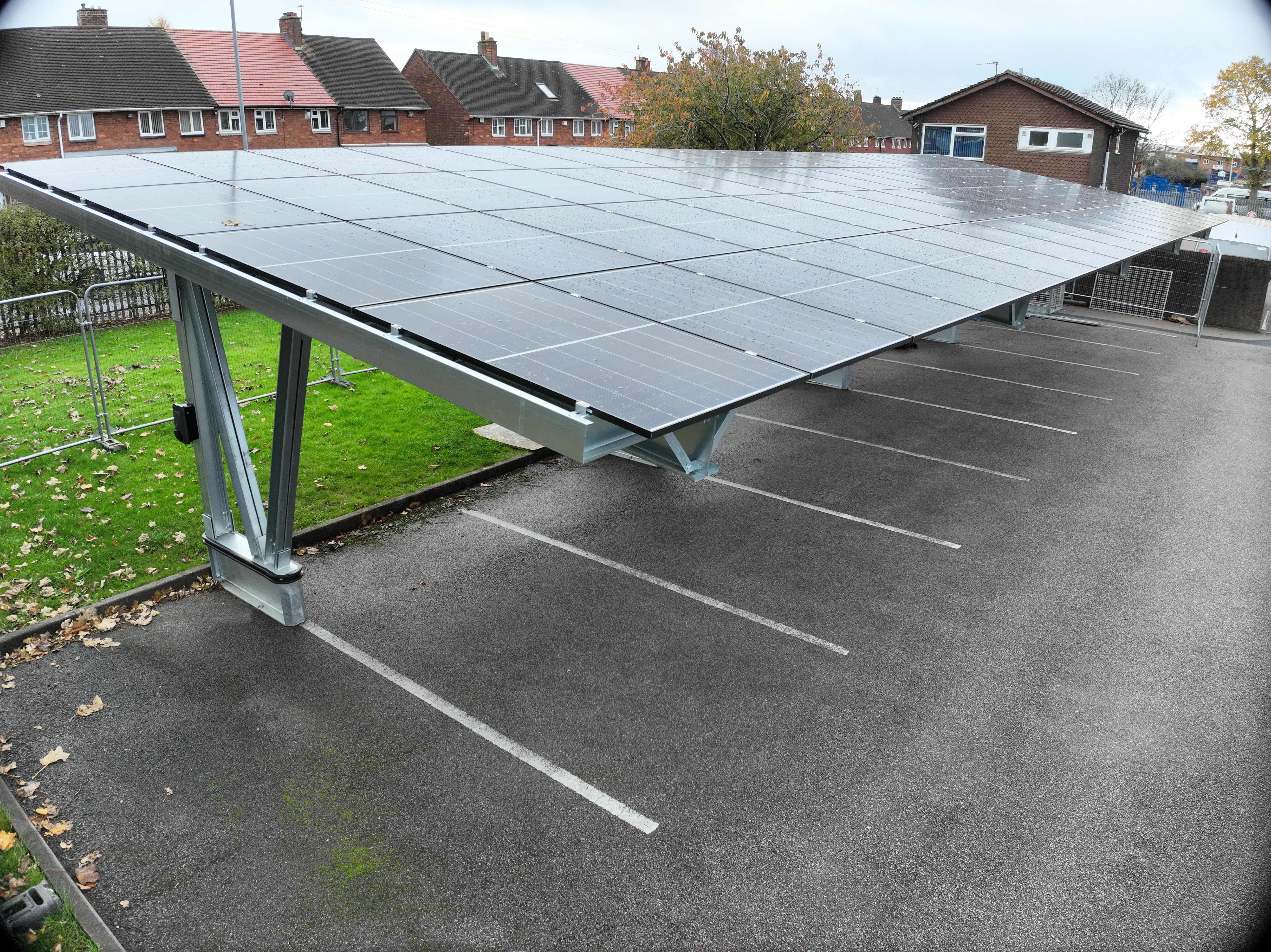 A SolarCatcher canopy structure installed in a car park with integrated solar panels and EV charging.