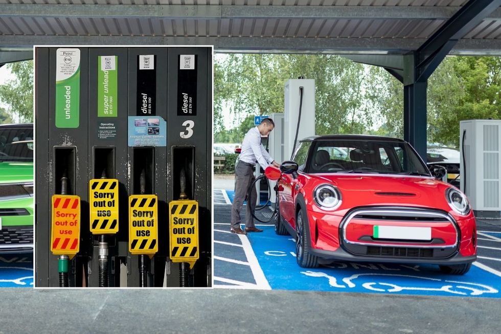 Man plugging charging cable into a red compact electric car at a covered EV charging bay; adjacent fuel pumps display yellow 'Sorry out of use' tags.