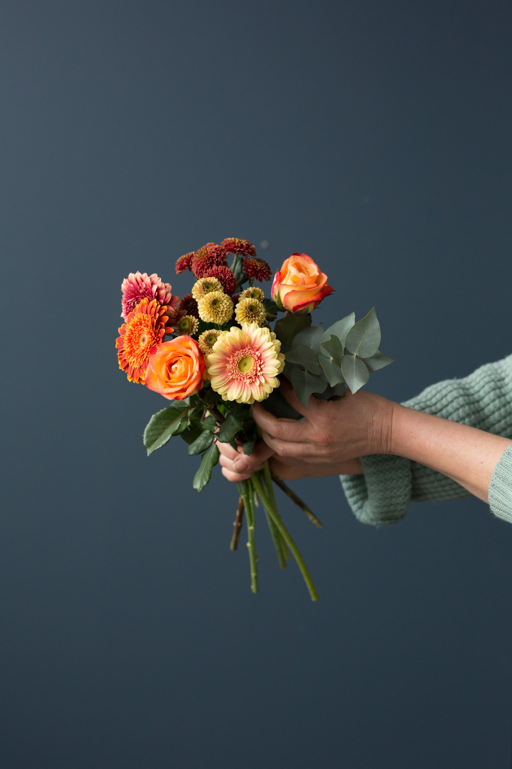 blanding av røde gule og oransj i en blomsterbukett