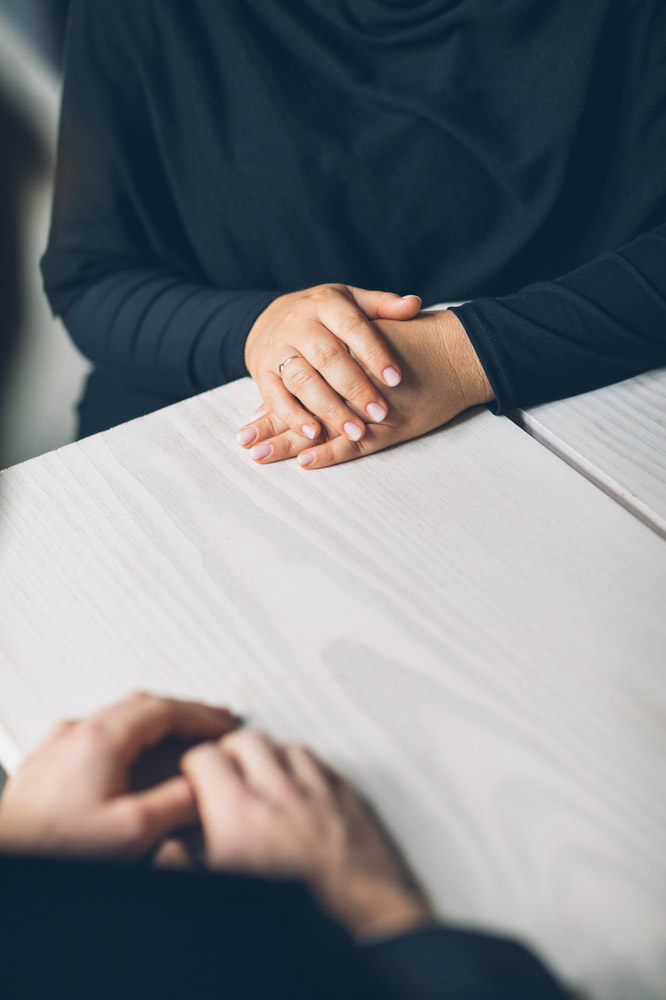 to personer som har en samtale ved et bord, bare hender er avbildet