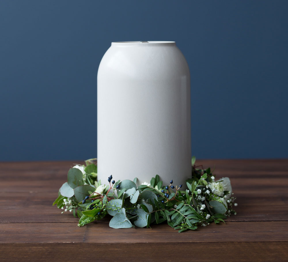 en urne med blomsterkrans rundt