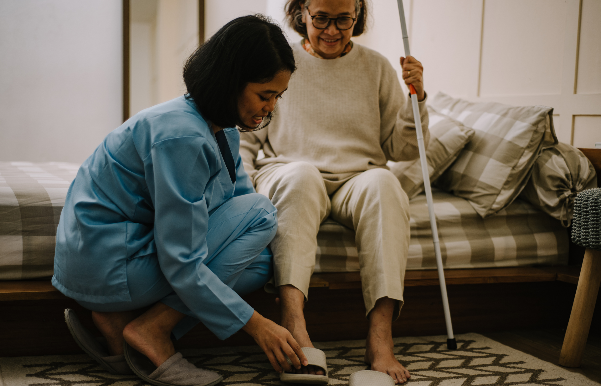 a carer hellping an old woman put on her shoes