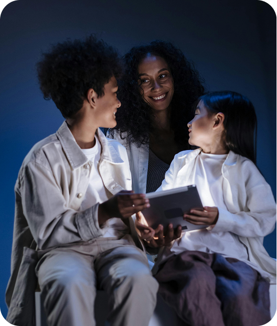 Children Sitting around a tablet smiling