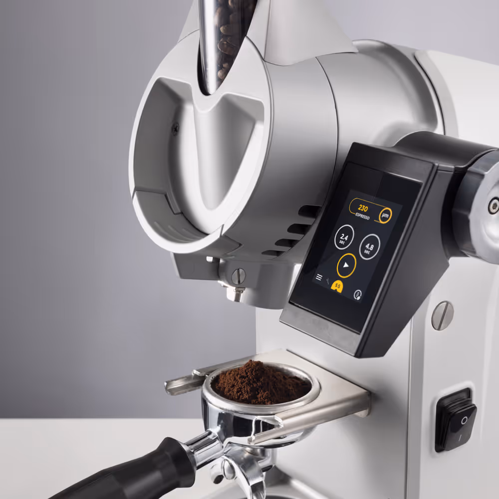 Weiße Kaffeemühle mit Bedienfeld mahlt Kaffee in einen Siebträger