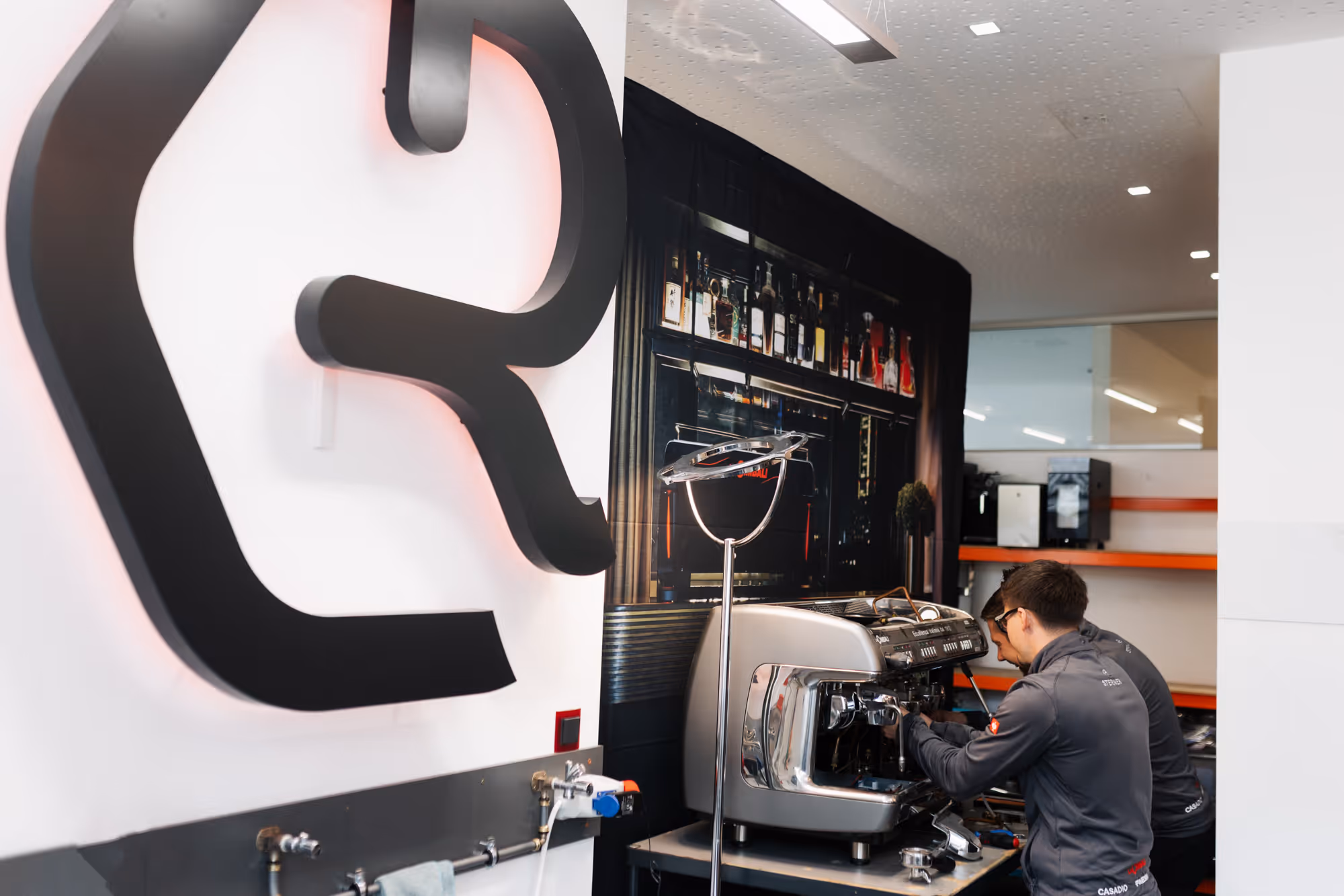 2 Männern reparieren eine Kaffeemaschine