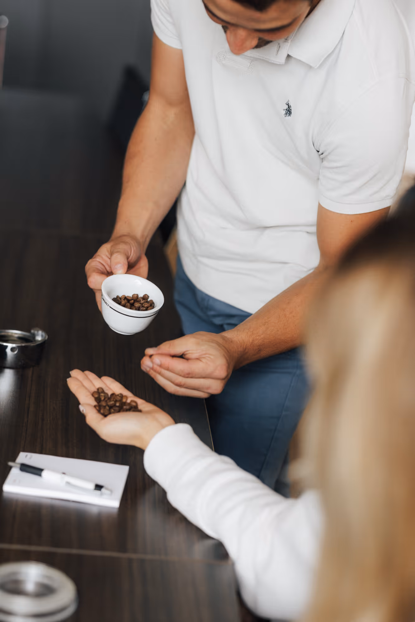Ein Mann und eine Frau mit einer Tassee Kaffeebohnen