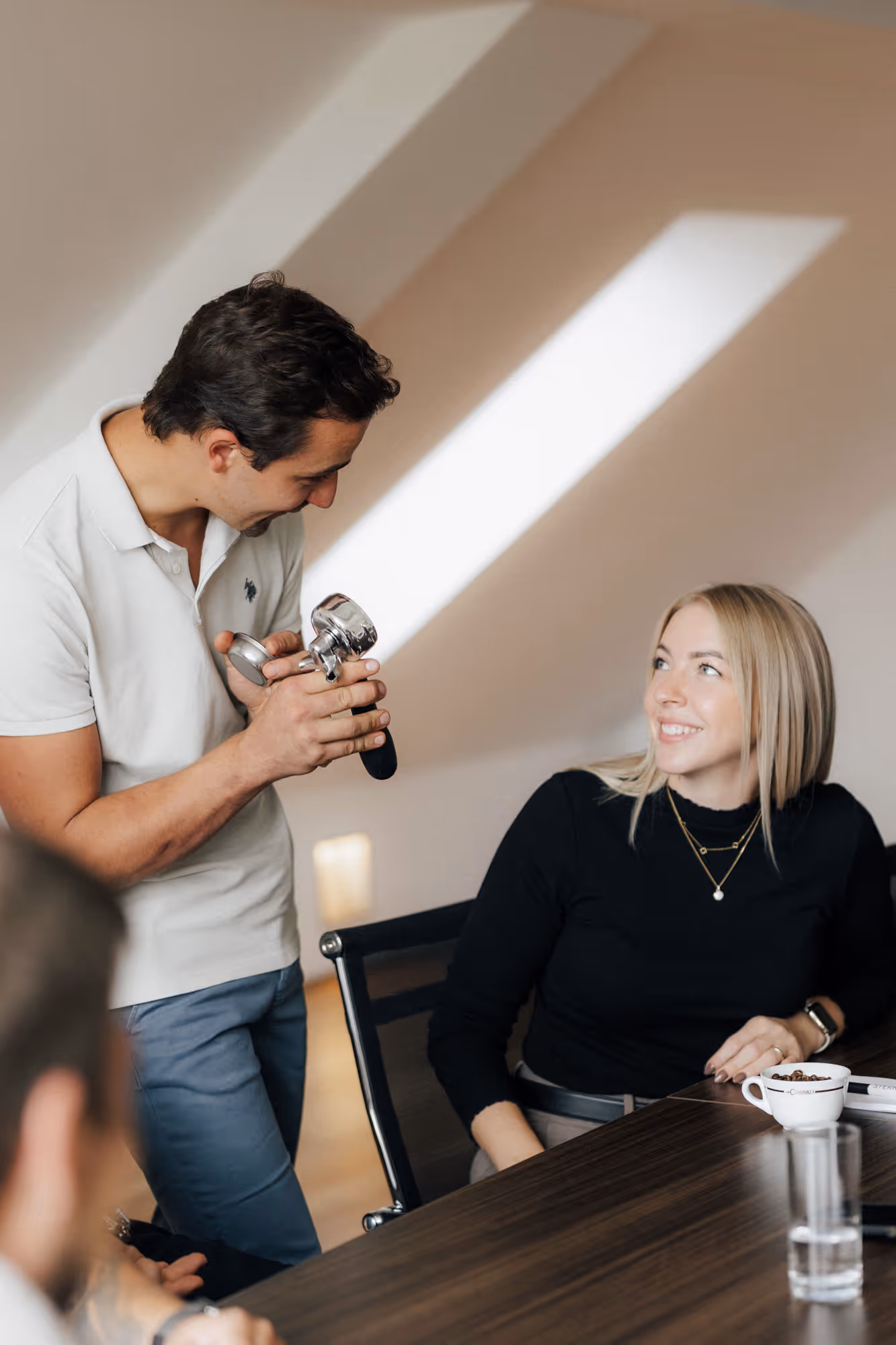 Ein Mann erklärt einer Frau, wie ein Kaffee gemacht wird