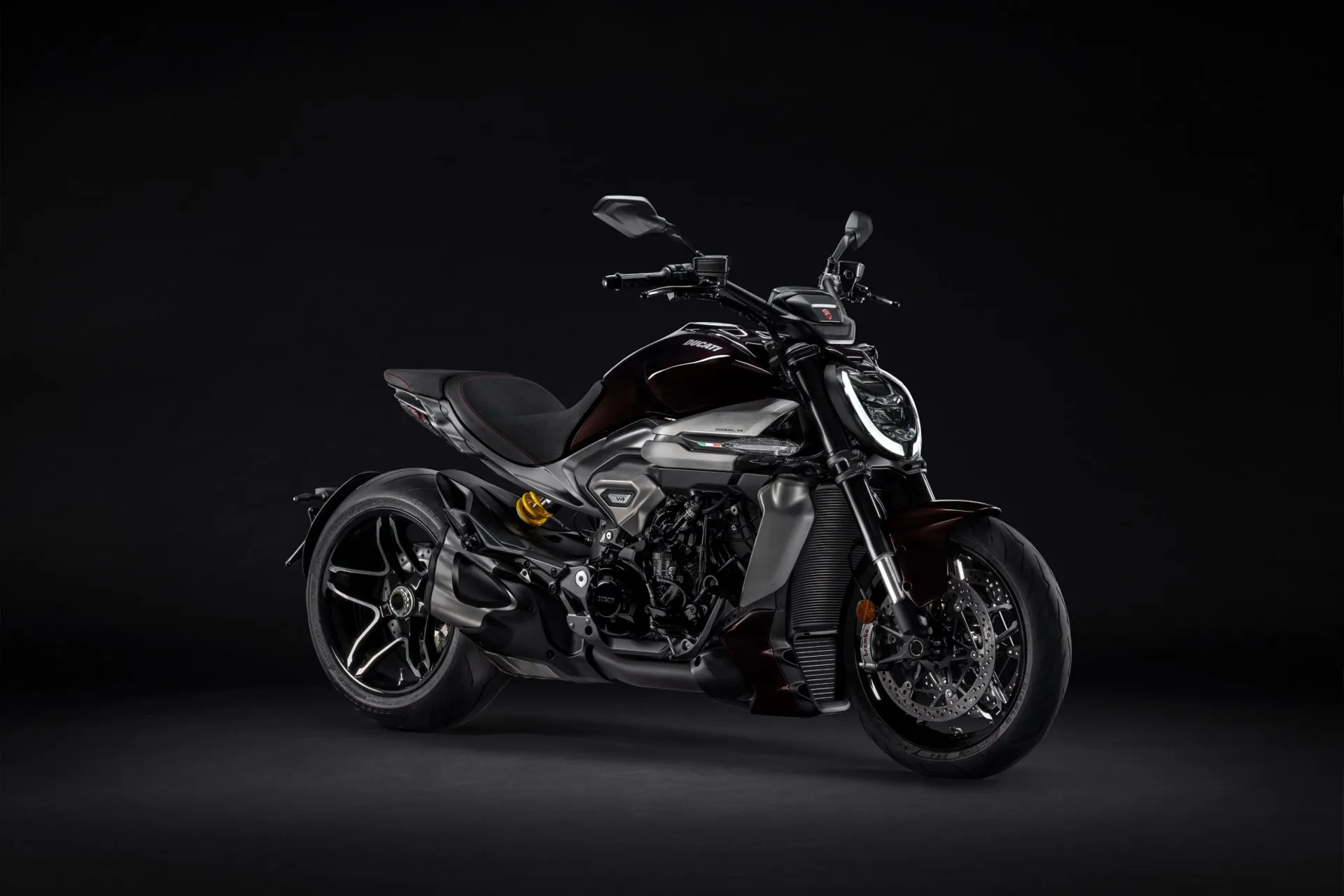 Schwarze Ducati Diavel V4 in Studioaufnahme vor schwarzem Hintergrund.