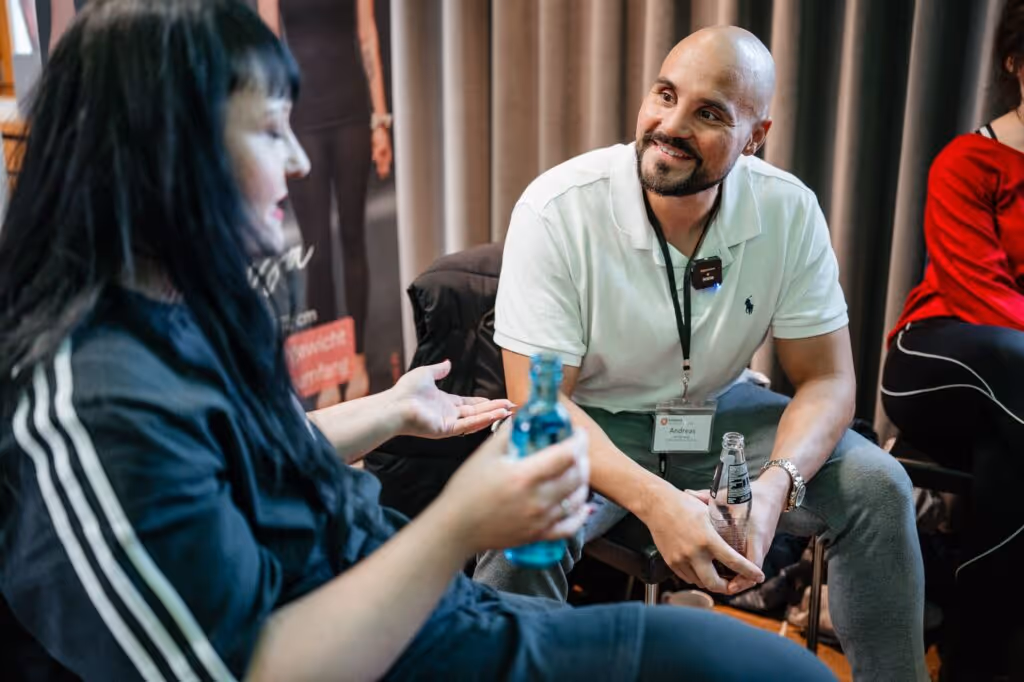 Andreas lacht und hört Alexandra zu