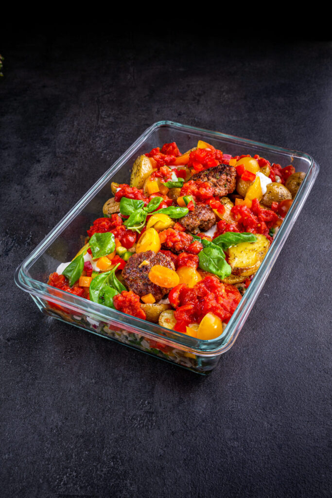 Kartoffelauflauf mit Hackbällchen, gelben Tomaten, Spinat und frischer Tomatensauce als herzhaftes Meal Prep Gericht für unterwegs oder fürs Büro