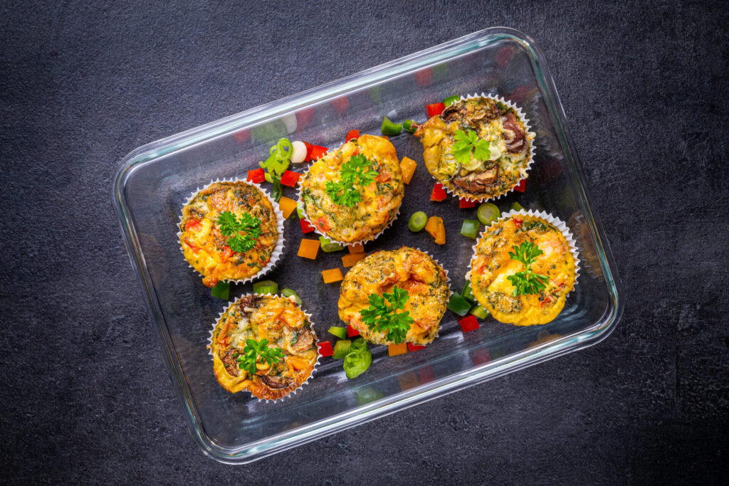 Gemüsemuffins mit Käse und Kräutern in einer Meal Prep Box als bunte proteinreiche Mahlzeit für unterwegs oder als Frühstück