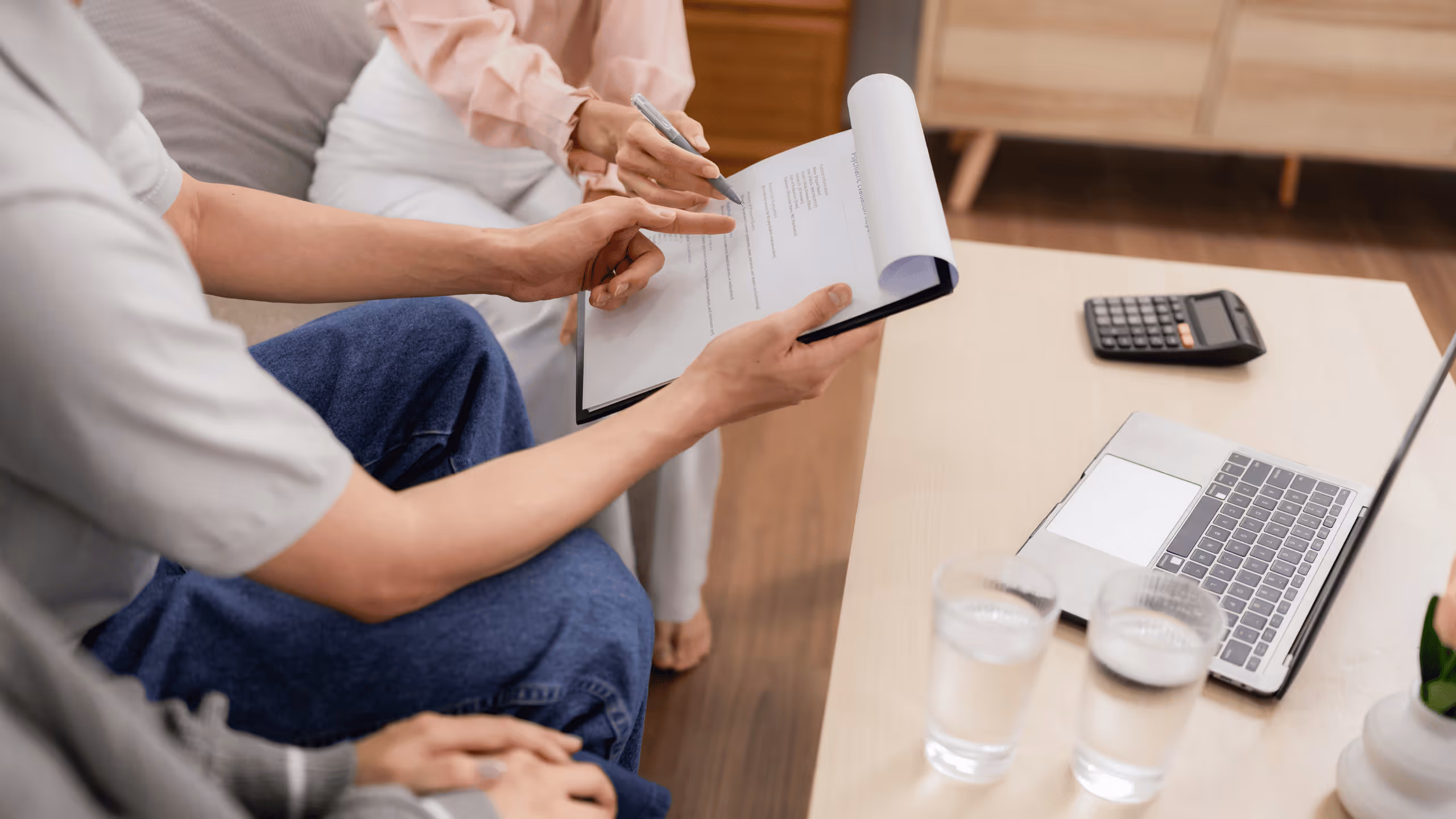 Beratungsgespräch zwischen Frau und Berater mit Dokumenten und Laptop – Beispiel für Ernährungsberatung im Zusammenhang mit Krankenkasse